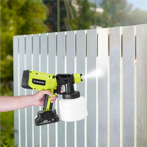 Person using a power sprayer to paint a wooden fence outdoors.