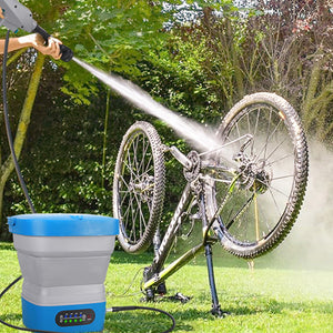 Person washing a bicycle with a high-pressure washer outdoors.