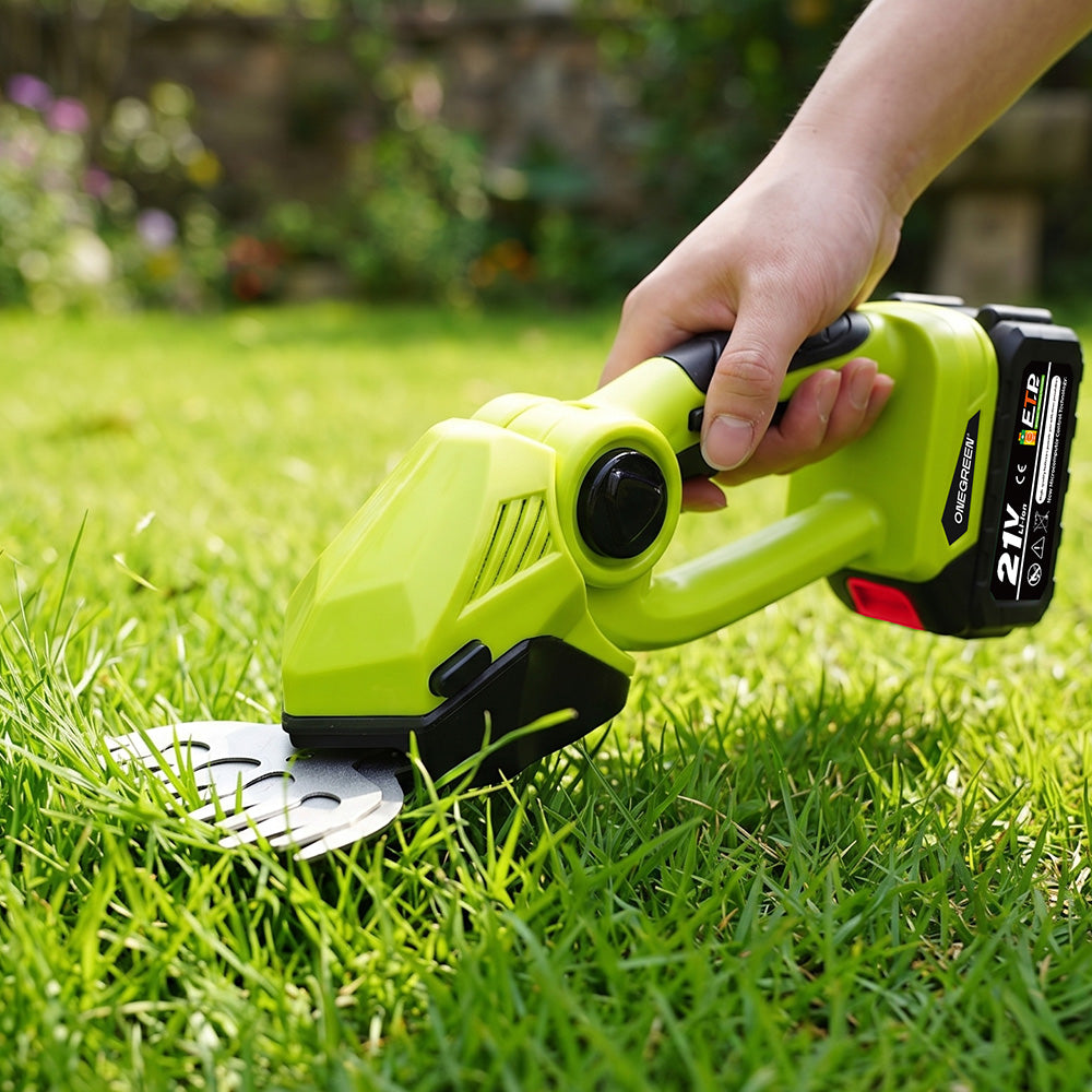 A cordless hedge trimmer in bright lime green and black being used by a person to trim green grass in a garden.